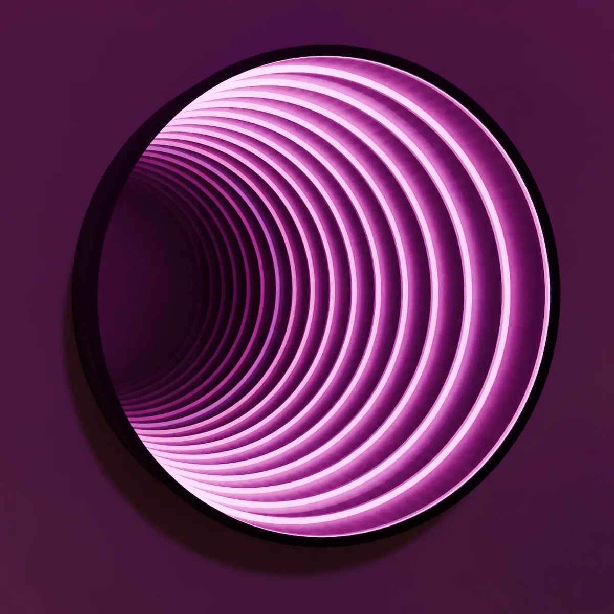 Round infinity mirror glowing pink with a deep tunnel effect