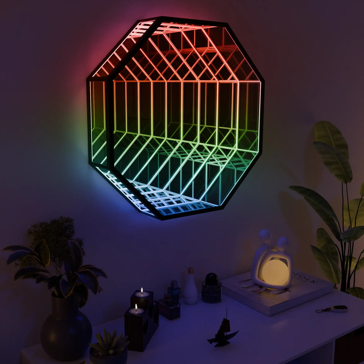 The 27.6 in Infinity OctaMirror lit in rainbow colors on a dark wall, above a white console with candles and plants