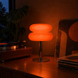 Aprica Table Lamp lit, orange glass shades glowing on a walnut credenza beside a turntable and records