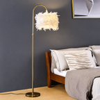 Feather lamp lit beside a bed with a dark wood headboard