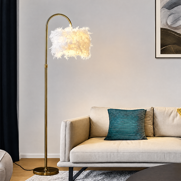 Gold feather floor lamp next to a beige sofa with a teal pillow