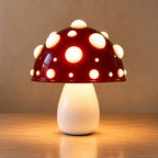 Small red mushroom lamp with white spots on an oak top against a plain warm wall