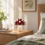 Small red mushroom lamp with white spots on a nightstand on a bright morning