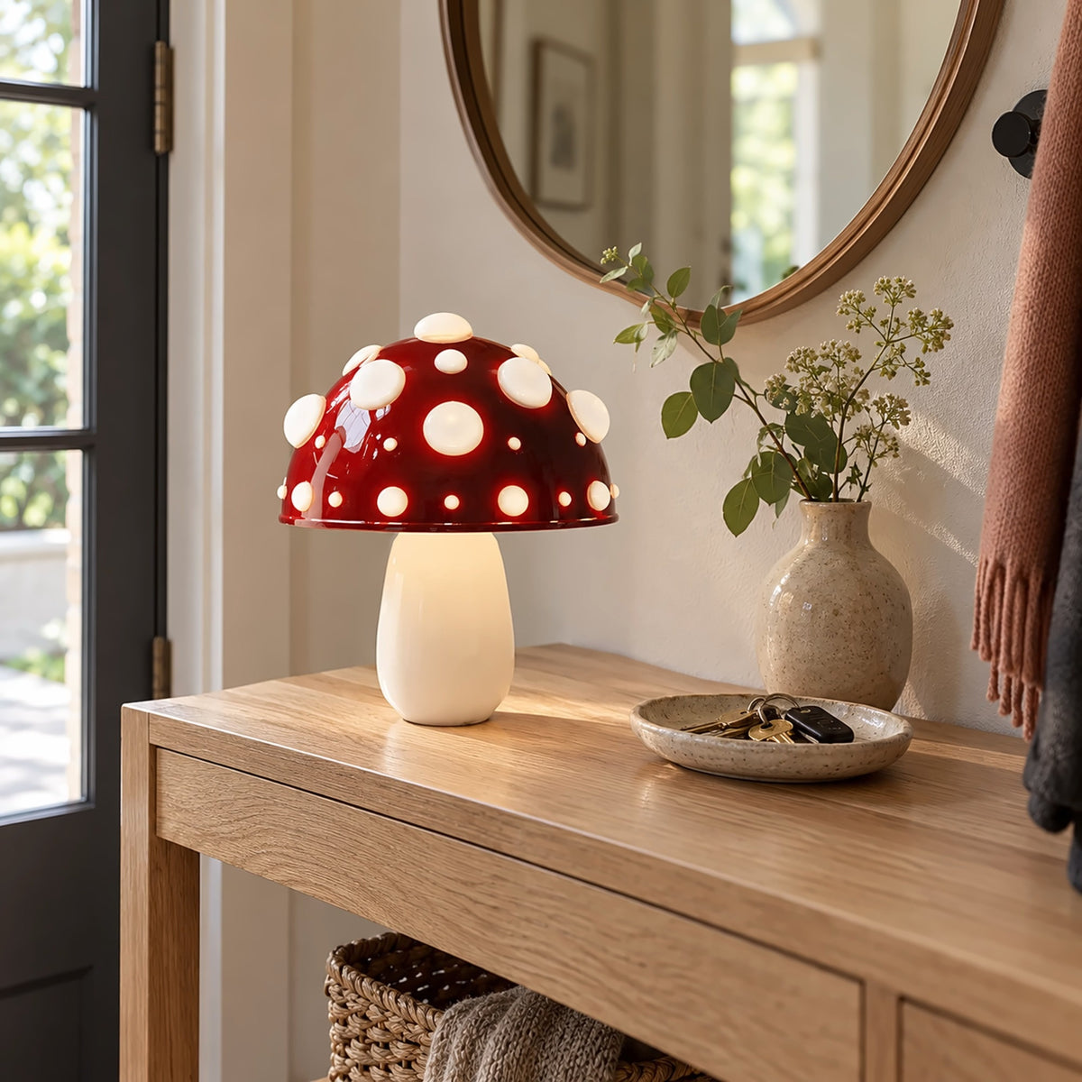 Small red mushroom lamp with white spots on an entryway console by the door