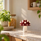 Small red mushroom lamp with white spots on a terrazzo kitchen counter