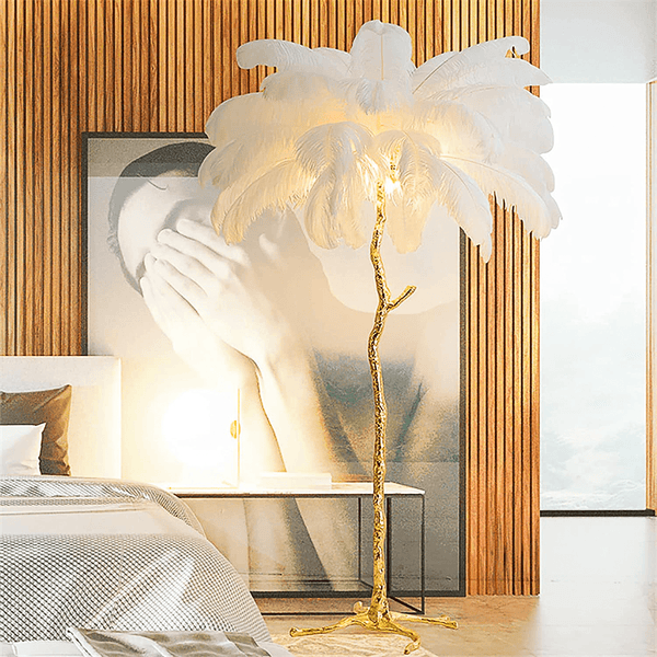 White feather floor lamp glowing beside a bed and wood-slat wall