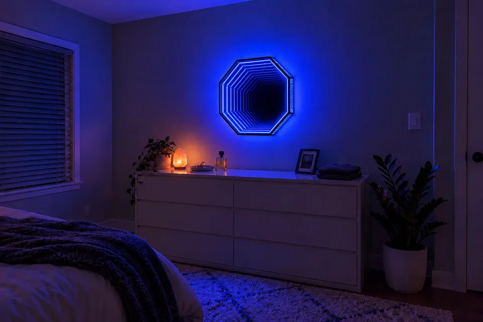A 19.7-inch Infinity OctaMirror glowing blue on the wall above a white dresser in a bedroom at night